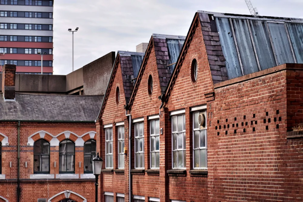 Historic red-brick buildings in Birmingham’s Jewellery Quarter under a cloudy sky