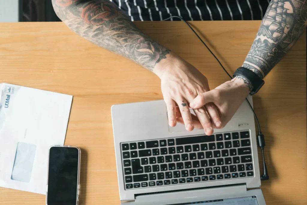 Small business owner typing a reply to customer reviews on a laptop
