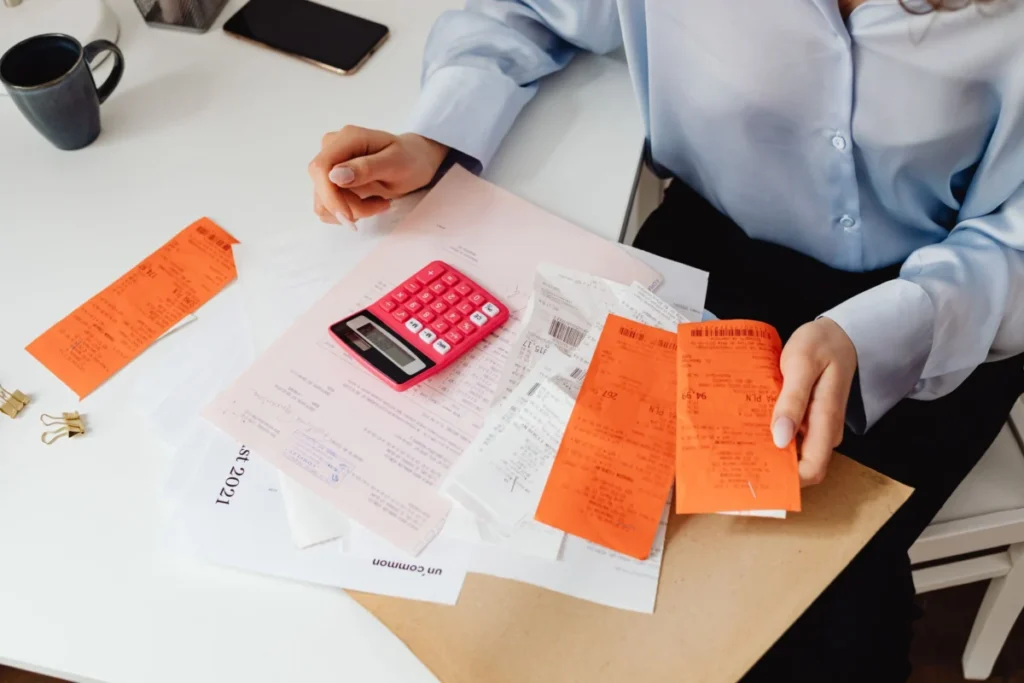 Business owner checking receipts with a calculator, as you would when reconciling VAT on Meta ad invoices