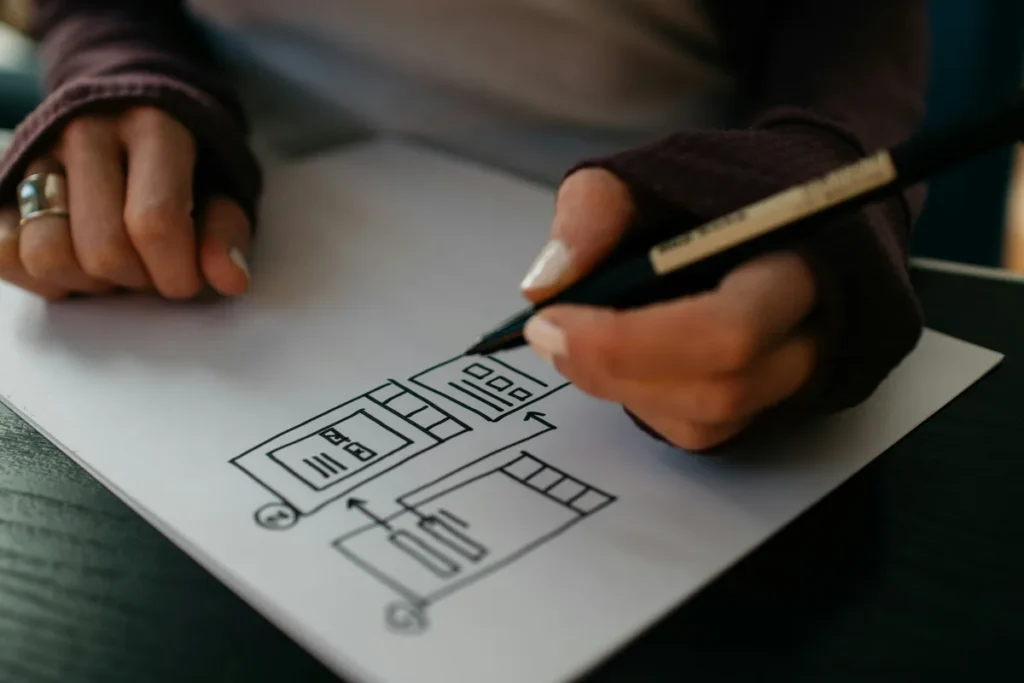 Web designer sketching a page layout on paper before any code is written